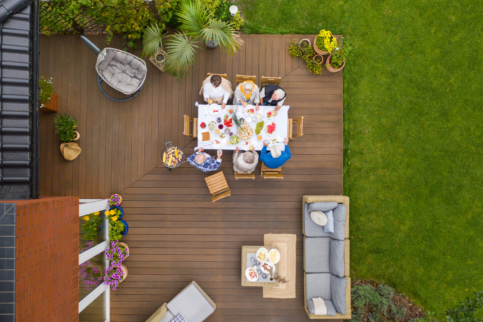 Gedeckter Tisch auf einer Holzterrasse von oben